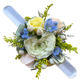 Small pastel corsage with blue and white flowers on a ribbon