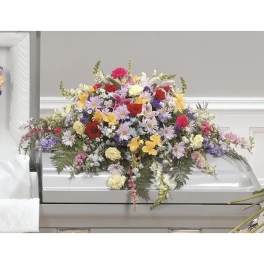 Large mixed flower spray on a white casket
