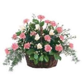 Pink and white flowers arranged in a wicker basket