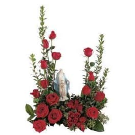 Red roses arranged around a small religious statue