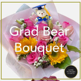 Bouquet of yellow sunflowers and pink roses with a small teddy bear in graduation attire.