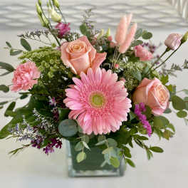 Pink gerbera daisy and roses in a glass vase