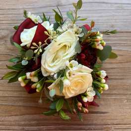 White rose bouquet with burgundy ribbon and greenery
