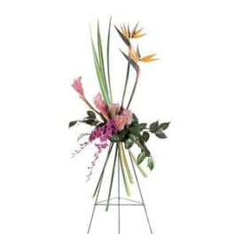 Tall tropical floral arrangement on a metal easel with pink and orange blooms
