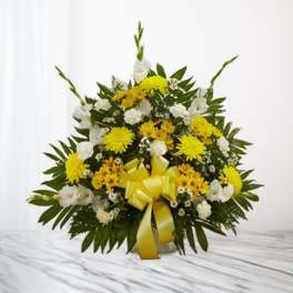 Yellow and white floral arrangement with a yellow ribbon