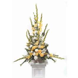Tall yellow and white floral arrangement in a basket on a pedestal