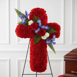 Red floral cross on a stand with roses and blue accents
