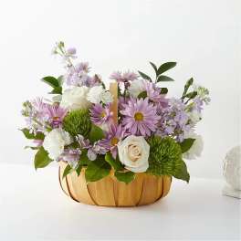 Basket arrangement of lavender daisies, white roses, and carnations