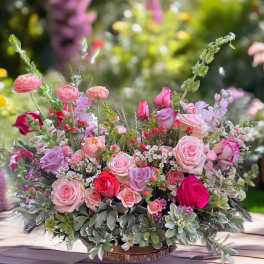 Mixed pink and lavender rose arrangement in a low container
