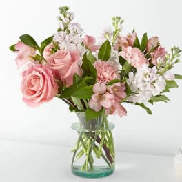 Pink roses and mixed pastel flowers in a clear glass vase