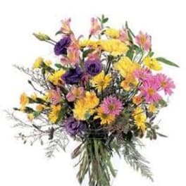Mixed bouquet of yellow, pink, and purple flowers in a glass vase
