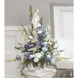 Tall white, blue, and purple floral arrangement in a white vase