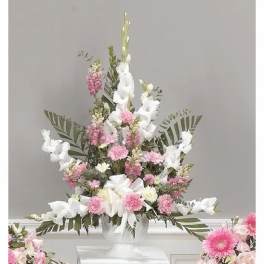 Tall pink and white floral arrangement in a clear vase