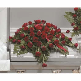 Large red rose casket spray on a silver coffin