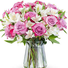 Pink roses and white alstroemeria in a clear glass vase