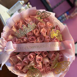 Bouquet of pink roses wrapped in pink paper with butterfly decorations