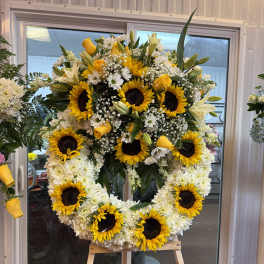 Large sunflower and white flower wreath on an easel