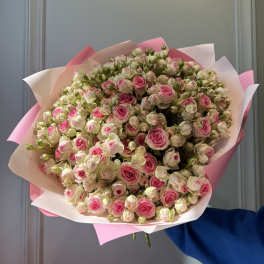 Large bouquet of pink and white spray roses wrapped in pink paper