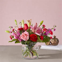 Pink and red mixed flower bouquet in a clear glass vase