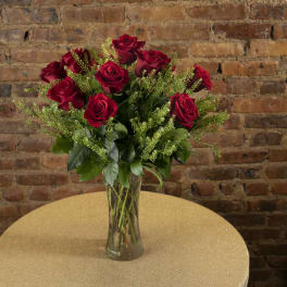 Red roses arranged in a clear glass vase