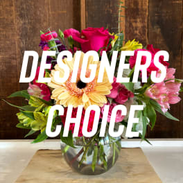 Mixed bouquet in a clear glass vase with a large yellow gerbera daisy and pink roses