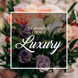 Mixed bouquet of pastel roses and purple blooms with greenery