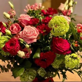 Bouquet of red and pink roses with green pom-pom blooms