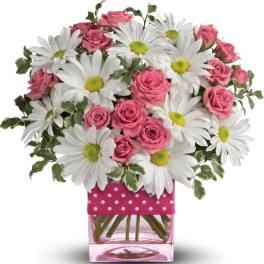 Pink roses and white daisies in a pink glass vase with white polka dots