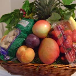Fruit basket with apples, mangoes, strawberries, and packaged snacks
