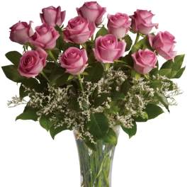 Pink roses arranged in a clear glass vase with white filler flowers