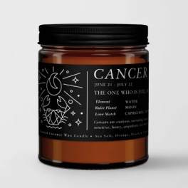 Amber jar candle with a black label reading Cancer