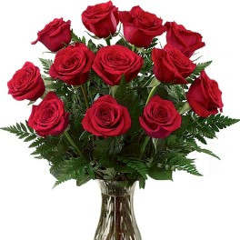 Red roses arranged in a clear glass vase
