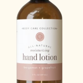 Amber pump bottle of hand lotion with a white and blush label