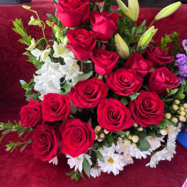 Tall arrangement of red roses with white lilies and daisies