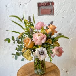 Mixed bouquet of pink and peach flowers in a glass vase