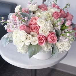 Pink and white rose bouquet in a white vase