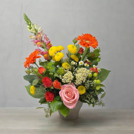 Mixed bouquet in a gray vase with pink and orange blooms