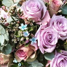 Bouquet of lavender and blush roses with small blue flowers