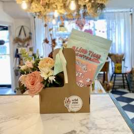 Flower gift bag with peach and white blooms and a coffee bag