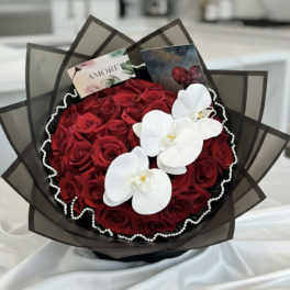 Bouquet of red roses with white orchids and dark wrapping