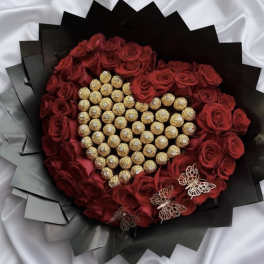 Heart-shaped bouquet of red roses with gold-wrapped chocolates and butterfly accents