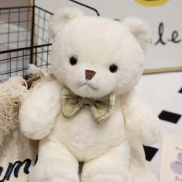 White teddy bear with a plaid bow tie