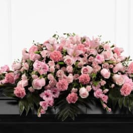 Pink floral casket spray with roses, lilies, and carnations