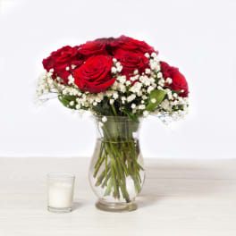 Red roses and white baby's breath in a clear glass vase