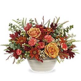 Autumn floral arrangement in a white ceramic bowl with yellow roses and red blooms