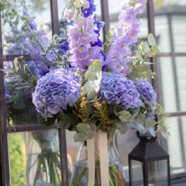 Lavender and blue floral arrangement in a clear glass vase