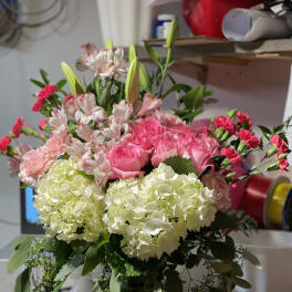 Pink roses and white hydrangeas arranged in a glass vase