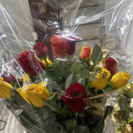 Bouquet of red and yellow roses wrapped in clear plastic