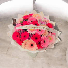 Bouquet of pink and peach gerbera daisies with a birthday ribbon