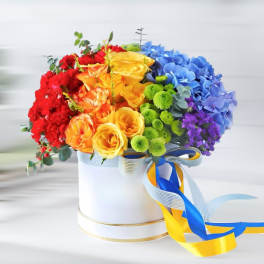 Rainbow bouquet of roses and hydrangeas in a white hat box